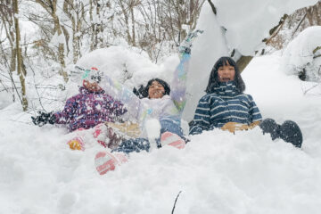 asobi基地ユニバーシティのプログラム「雪国古民家生活（富山県利賀村） 」でたくさんの雪の中で笑顔を見せる小学生たち